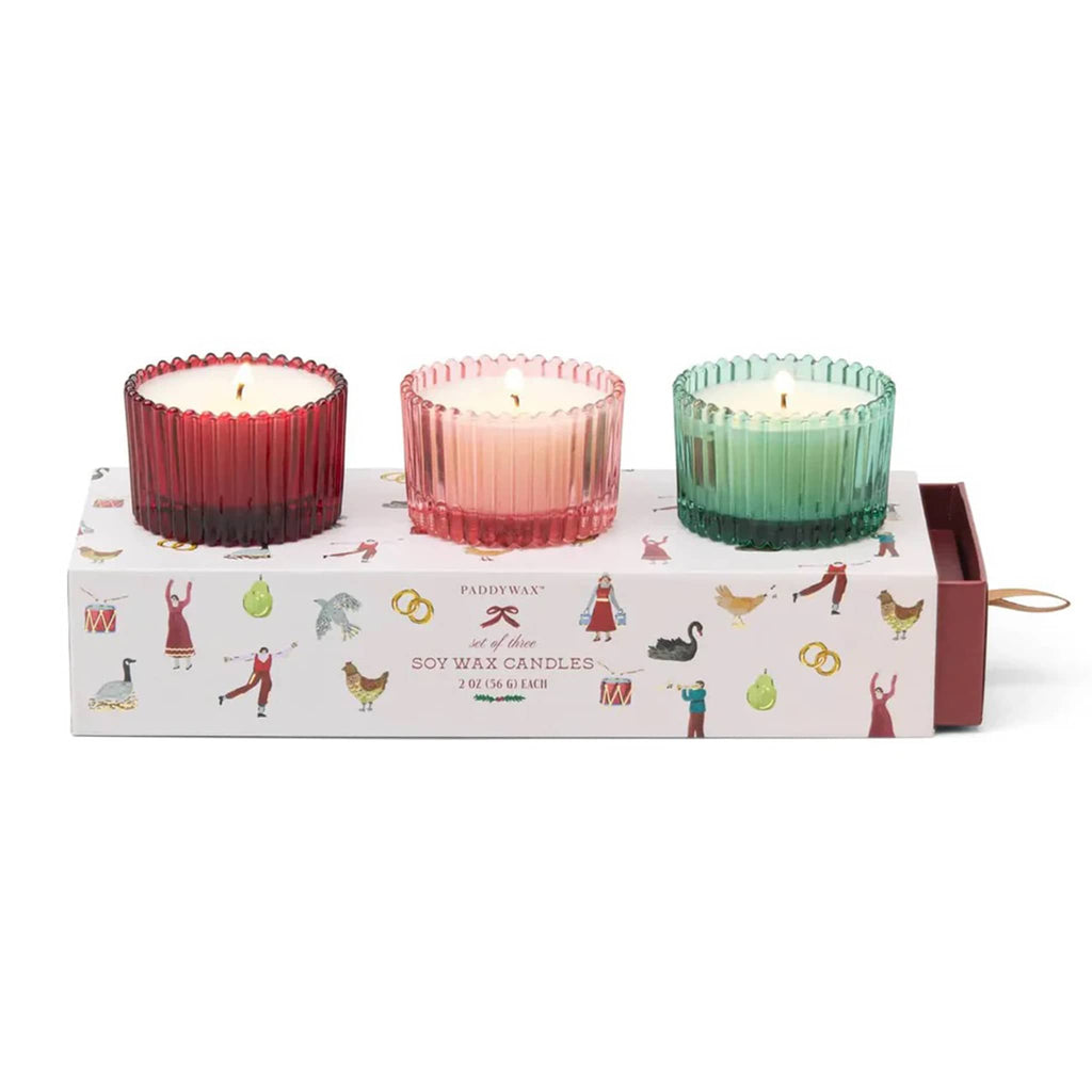 Three colorful candles in a decorative box with holiday illustrations on a white background.