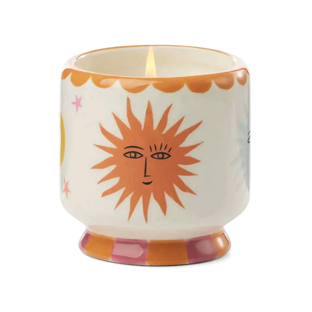 Paddywax A Dopo 8 ounce Orange Blossom scented candle in a ceramic vessel hand painted with a sun, moon and stars design.