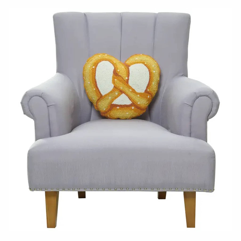 Peking Handicraft pretzel hook wool throw pillow, on gray chair.