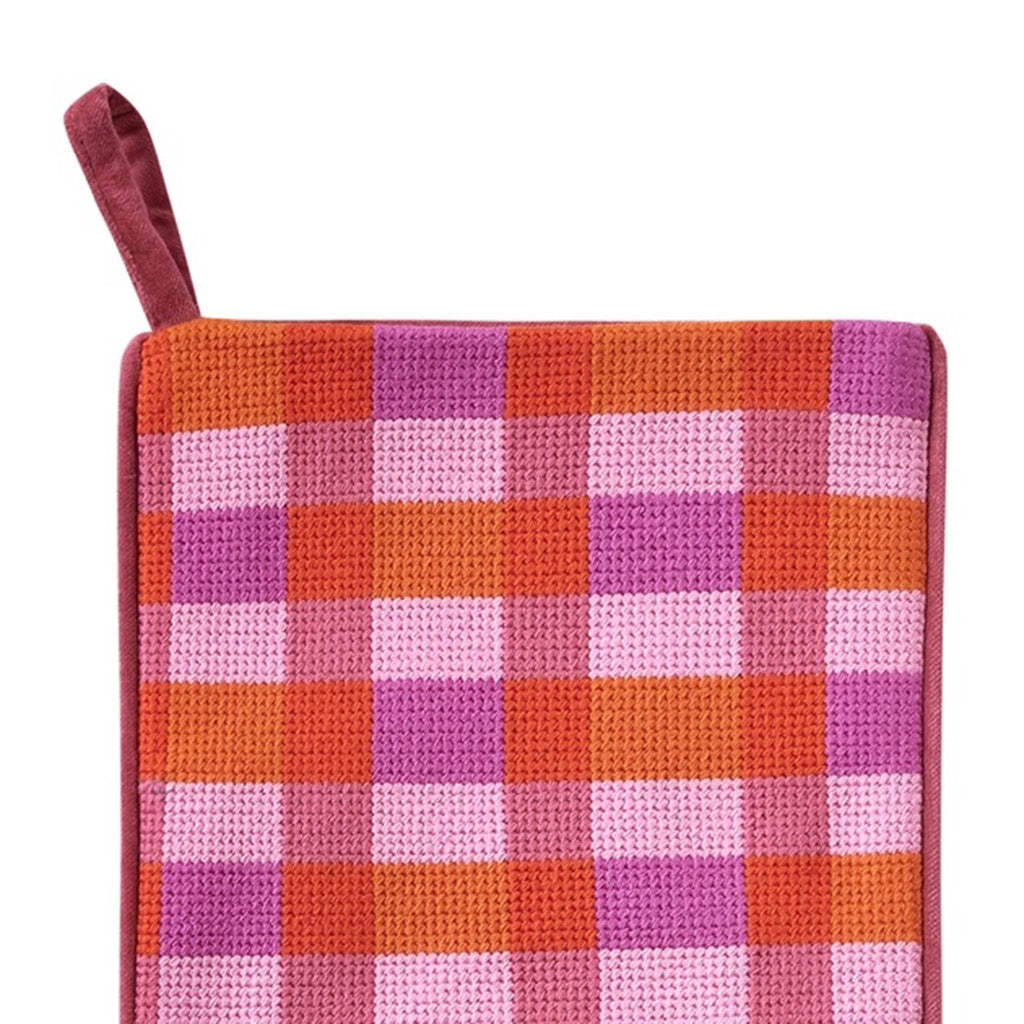 Abstract Plaid Christmas needlepoint stocking with pink and red pattern, detail of loop on a white background.