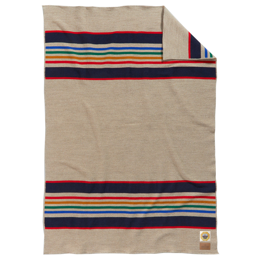 Pendleton Yellowstone National Park Throw Blanket in taupe with red, navy, blue, green and orange stripes at both ends, full blanket shown with a corner folded back.