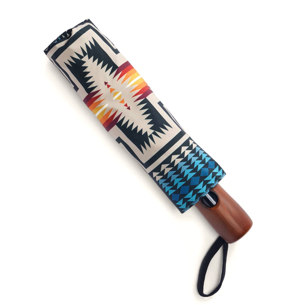 Umbrella in matching sleeve with a colorful pattern, on a white background.