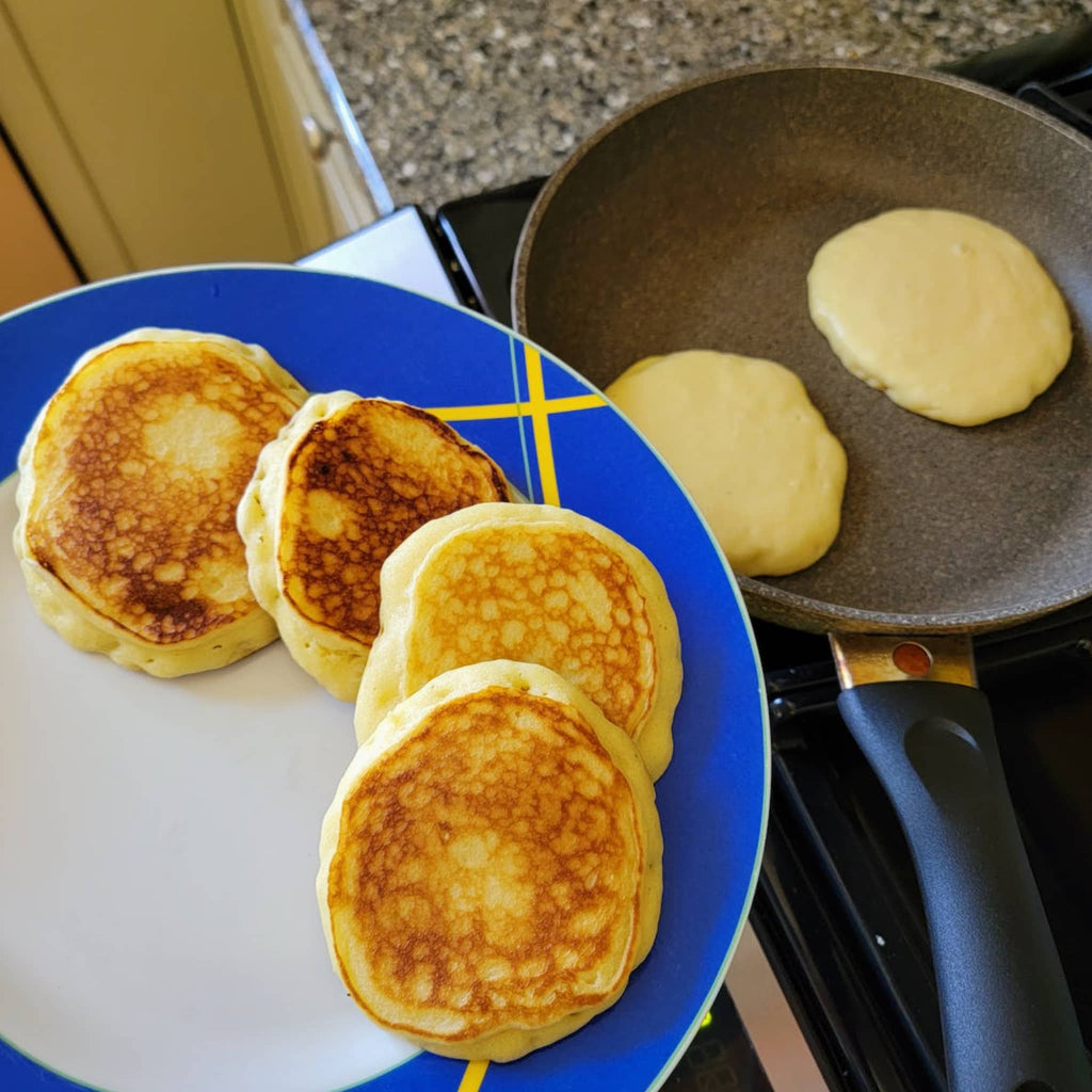 Phoenicia Diner Buttermilk Pancake Mix, finished pancakes with some cooking in a pan on the stove top.