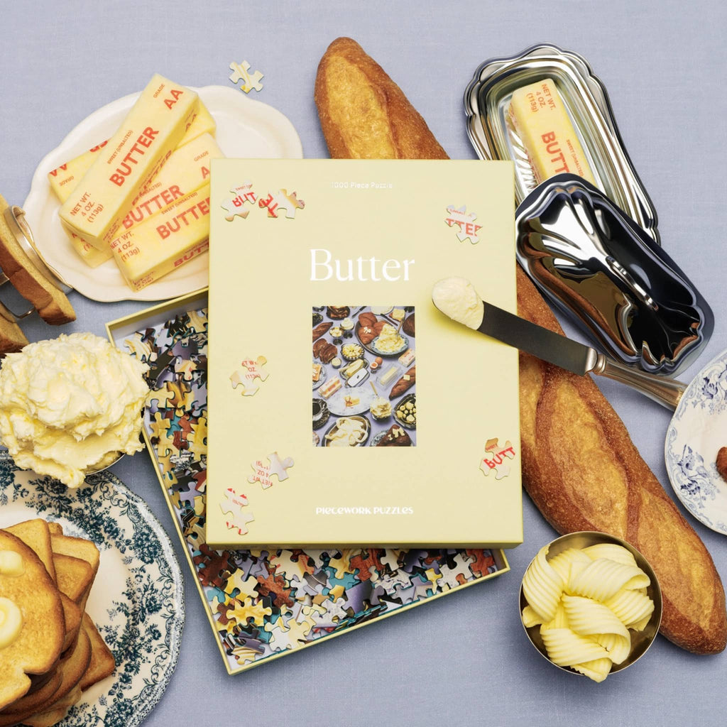 Butter-themed puzzle box with butter slices, a loaf of bread, and a knife on a blue-gray background.