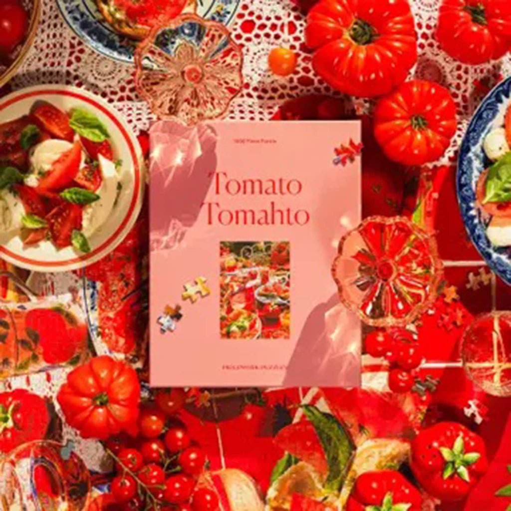 Piecework Puzzles 1000 piece tomato tomahto jigsaw puzzle in box packaging, surrounded by tomatoes.