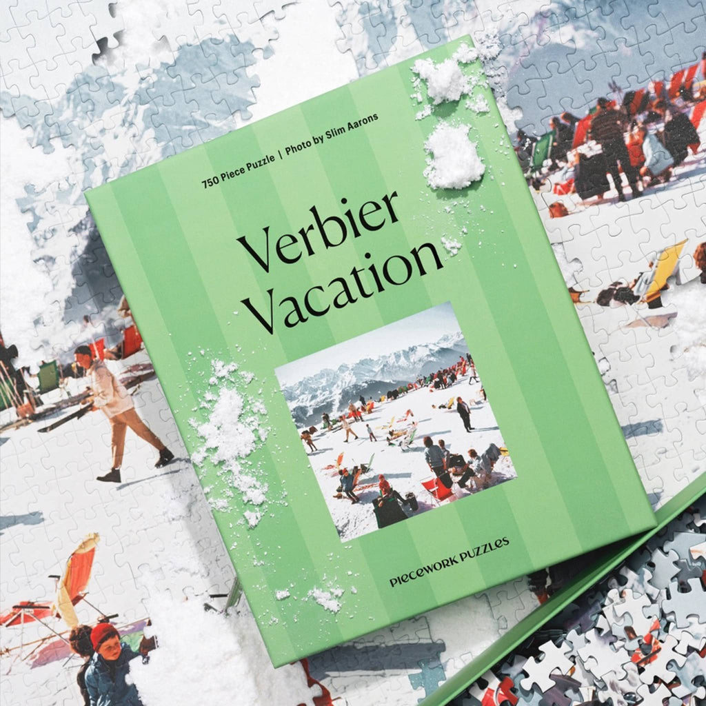 Jigsaw puzzle box titled 'Verbier Vacation' on a partially completed puzzle with winter scene pieces.