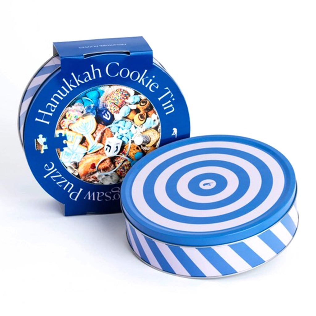 Piecework Puzzles 750 Piece Hanukkah Cookie Tin Round Jigsaw Puzzle in blue and pink striped tin packaging with blue sleeve that has the puzzle image on it.