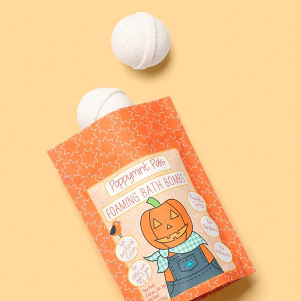 Pumpkin-themed foaming bath bombs with packaging on a yellow background.