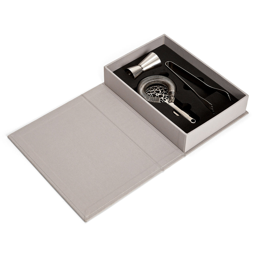Printworks The Essentials Cocktail Tools for Bar Lovers, set of 3 stainless steel bar tools in gray book box packaging, open showing tools resting inside on a matte black surface.