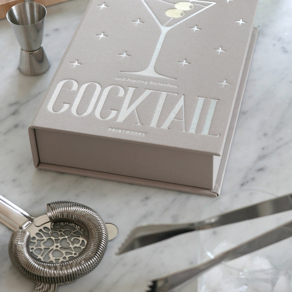 Printworks The Essentials Cocktail Tools for Bar Lovers, set of 3 stainless steel bar tools with gray book box packaging, on a marble surface.