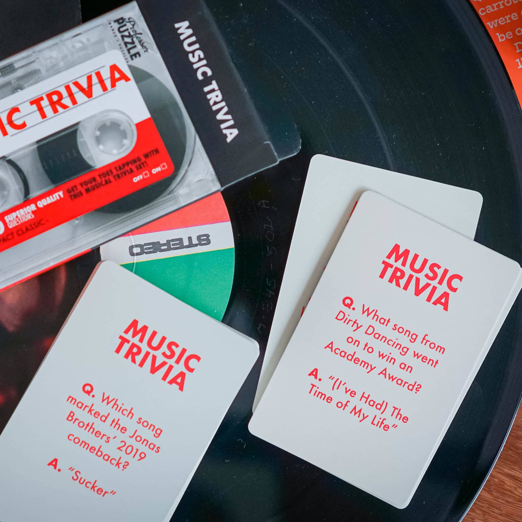 Music trivia cards with a cassette tape on a vinyl record.