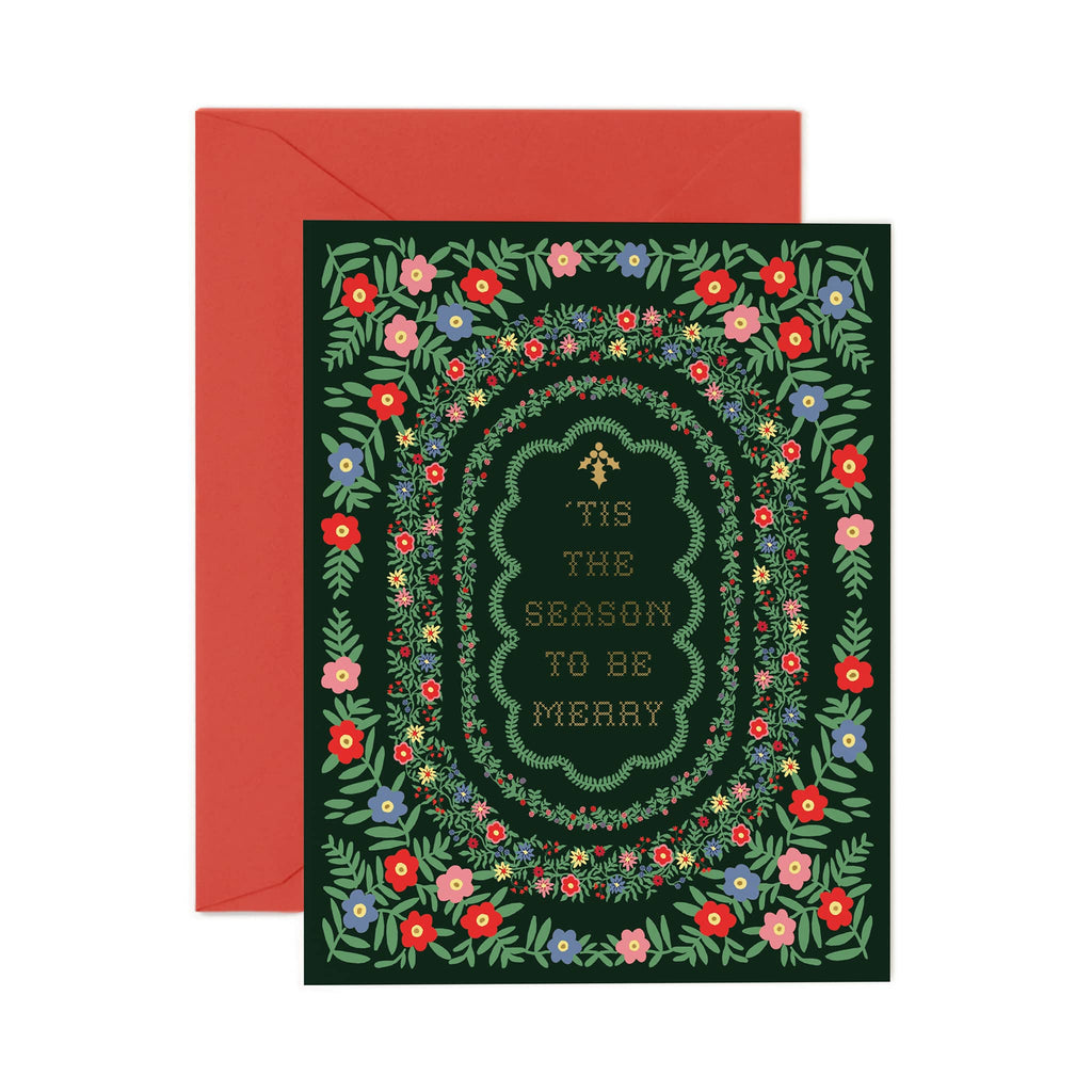 Greeting card with floral design and text 'Tis the season to be merry', featuring a red envelope.