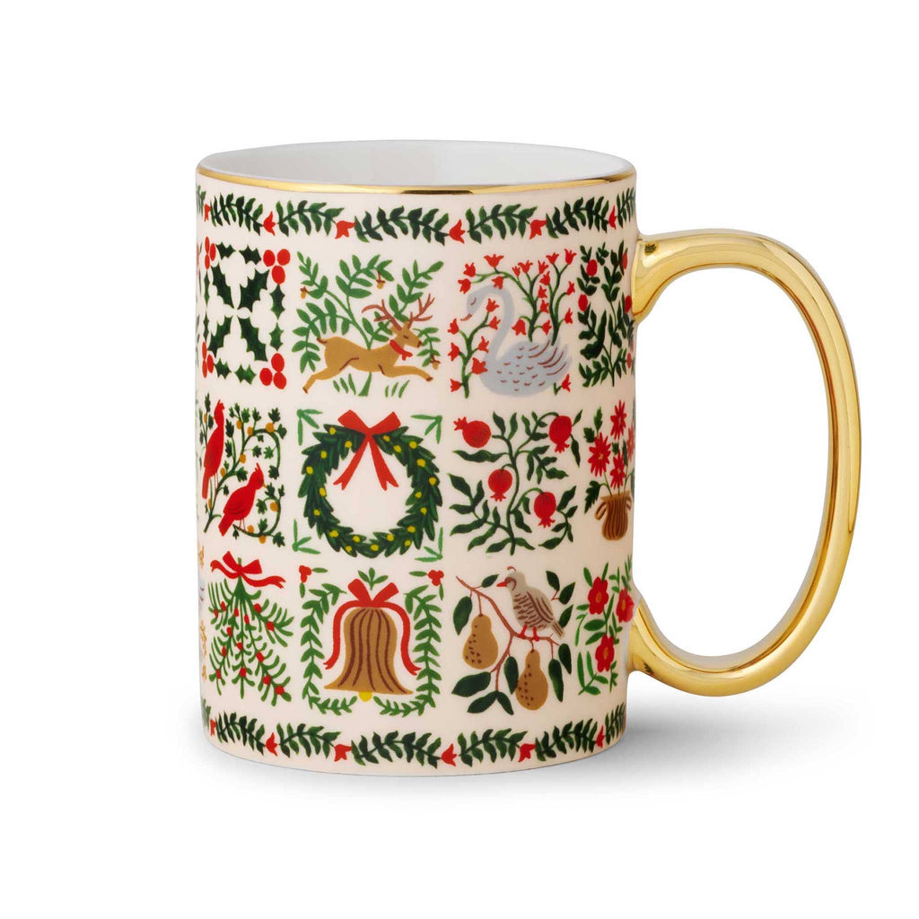 Rifle Paper Co. Christmastide porcelain holiday mug with gold rim and handle on right.