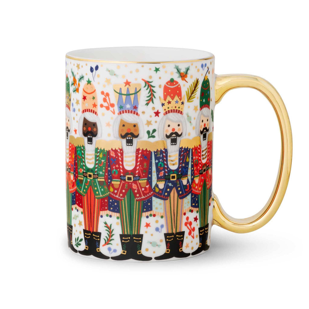 Rifle Paper Co. Nutcracker Brigade porcelain mug with gold rim and handle on the right.