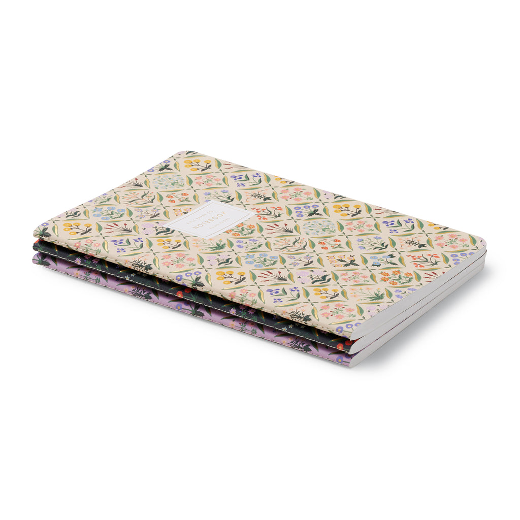 Rifle Paper Co. Estee Stitched Notebook Set of 3, stacked view of floral front covers in cream, navy and violet, side view.
