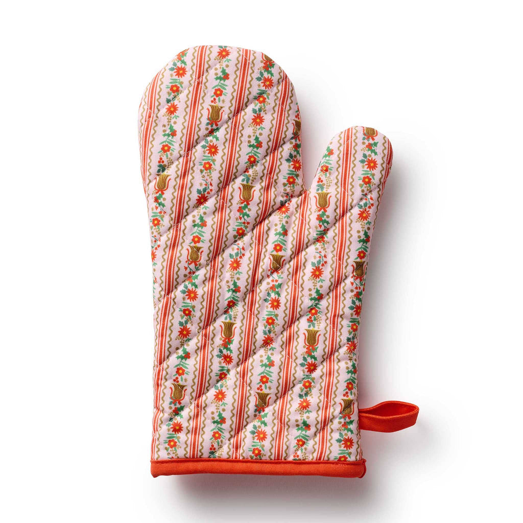 Decorative oven mitt with floral and bell pattern in pink and red, on a white background.