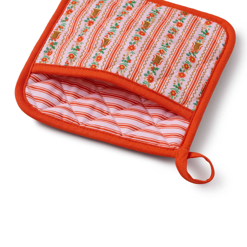 Potholder with red and pink floral and striped patterns on a white background.