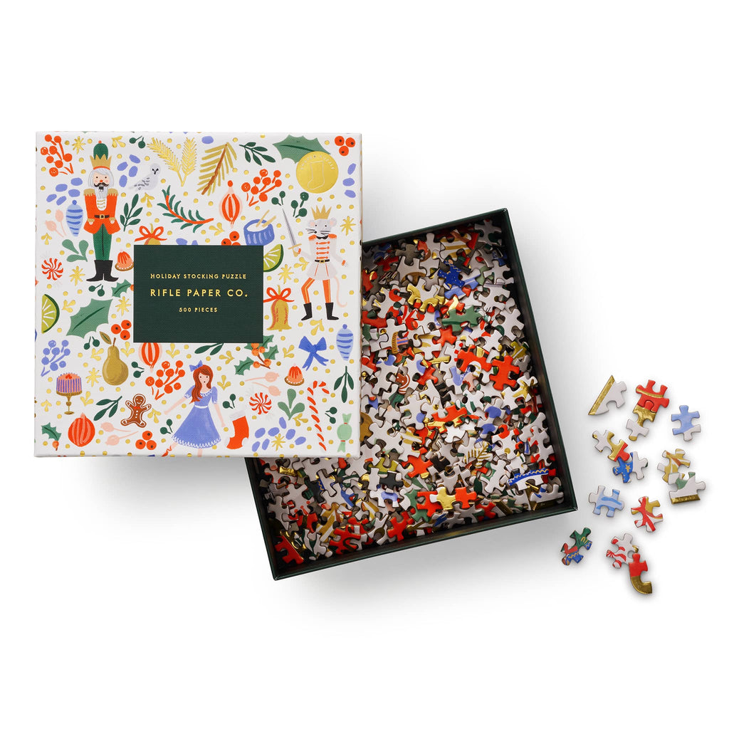 Rifle Paper Co. holiday stocking puzzle box with colorful illustrations, lid off to show pieces inside, on a white background.