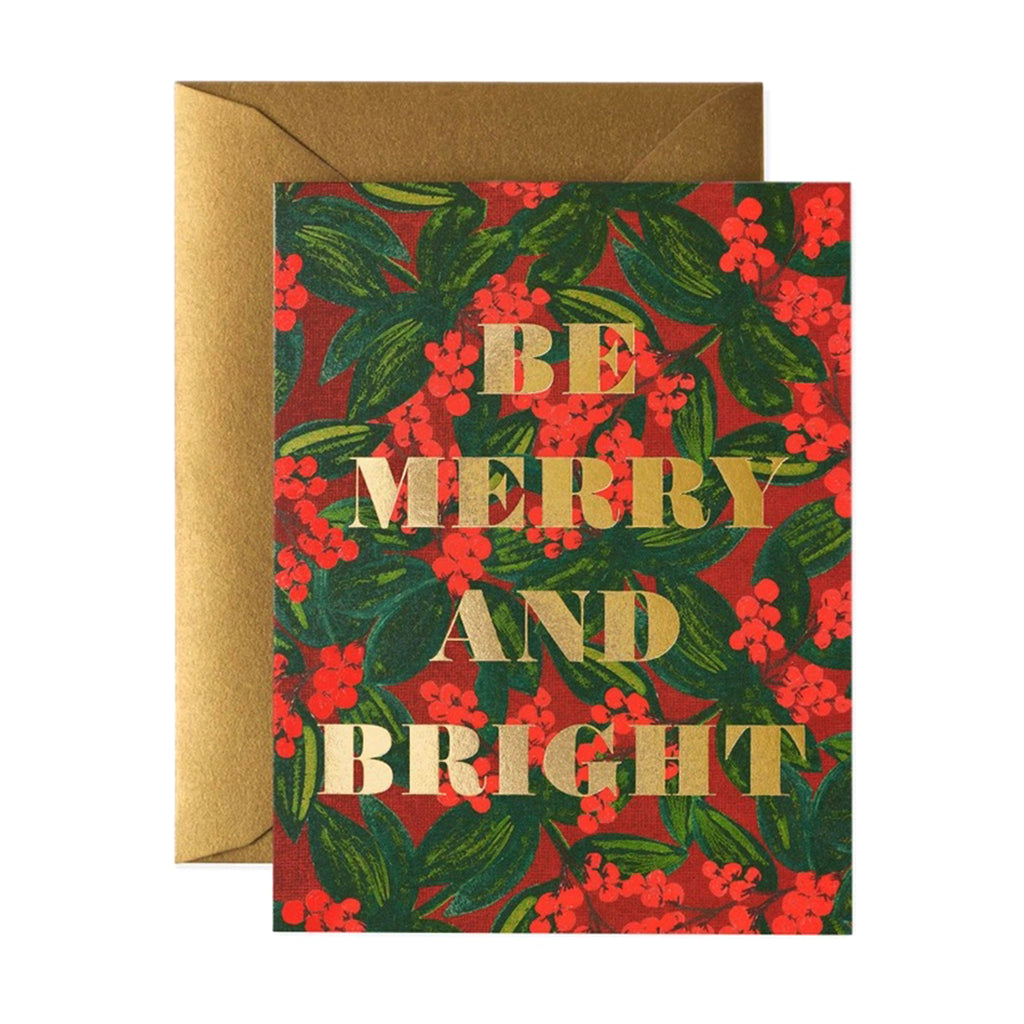 Rifle Paper Co. Merry Berry Christmas holiday greeting card with metallic gold foil envelope. Front of card has an illustration of red berry clusters and green leaves with "Be Merry and Bright" in gold foil lettering.