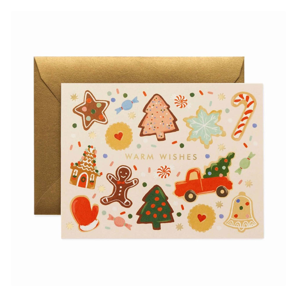 Rifle Paper Co. Holiday Cookies Christmas greeting card with matching metallic gold foil envelope. Front of card has a decorated cutout cookie design with candy pieces and sprinkles with "Warm Wishes" in gold foil lettering in the middle on a pale pink background.