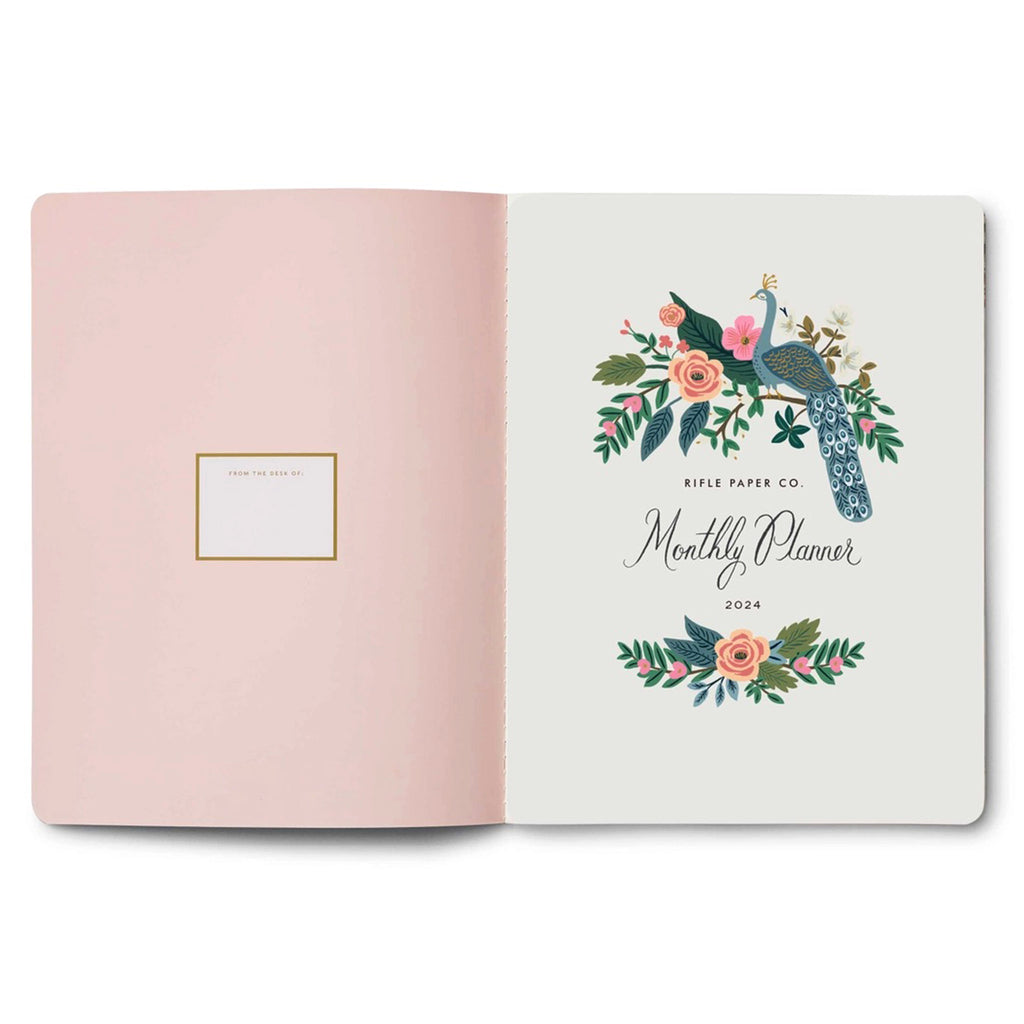 Rifle Paper Co. 2024 Monthly Planner Appointment Notebook, inside front cover, title page with signature Peacock floral motif opposite a solid blush pink page.
