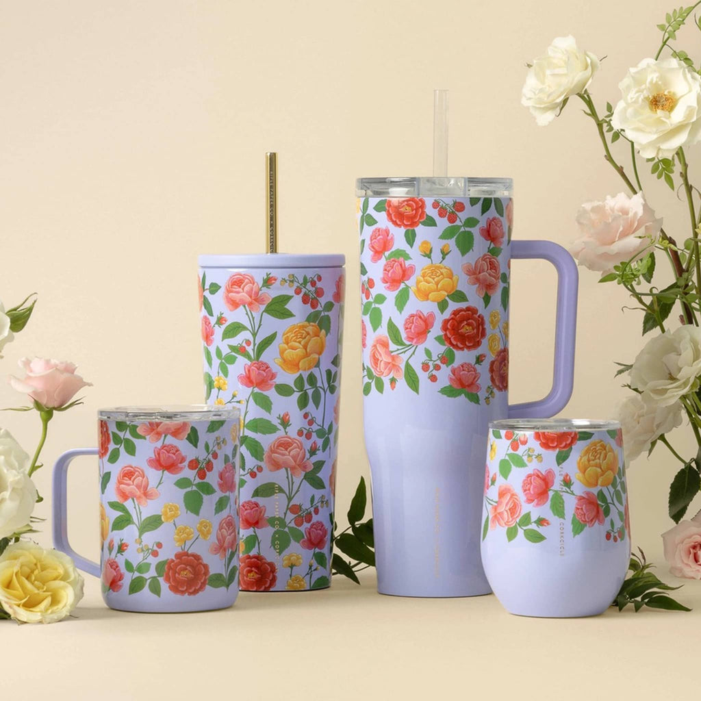 Rifle Paper Co. x Corkcicle insulated stainless steel mug, cold cup, cruiser and stemless cup with the Roses floral print on a purple background lined up on a cream background with roses.