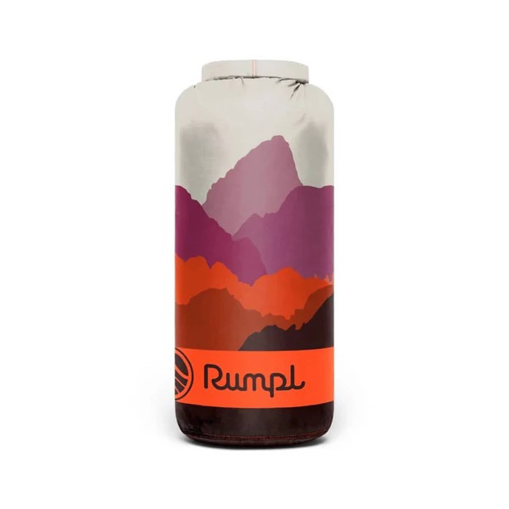 Rumpl Teton Dusk original puffy blanket with an abstract mountain design in brown, orange and purple, rolled up in matching stuff sack carrier, on a white background.