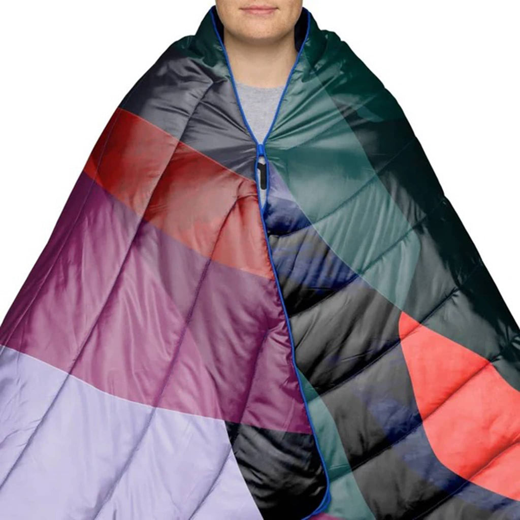 Person wrapped in a colorful puffy blanket with abstract pattern on a white background.