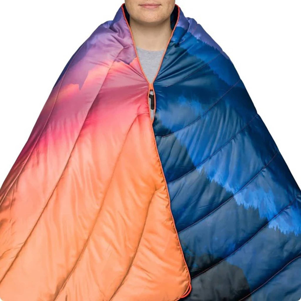 Person wrapped in a colorful sleeping bag with gradient colors from orange to pink to purple to blue.