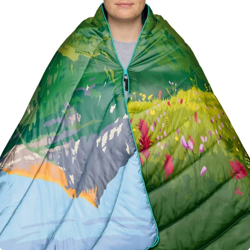Person wrapped in a puffy blanket with nature-themed design on a white background.