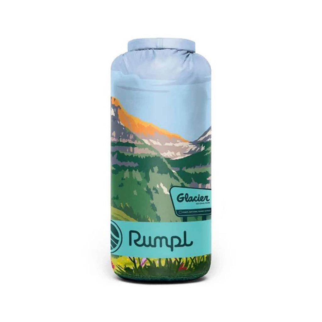 Rumpl Glacier National Park original puffy blanket with a scenic design of mountains and flowers, rolled up in matching stuff sack, on a white background.
