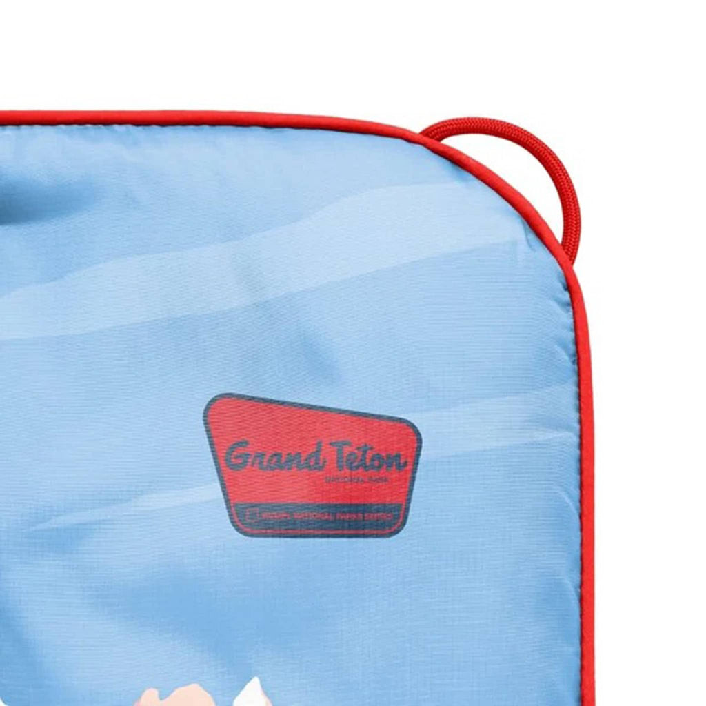 Corner of puffy blanket with 'Grand Teton' logo on a white background.