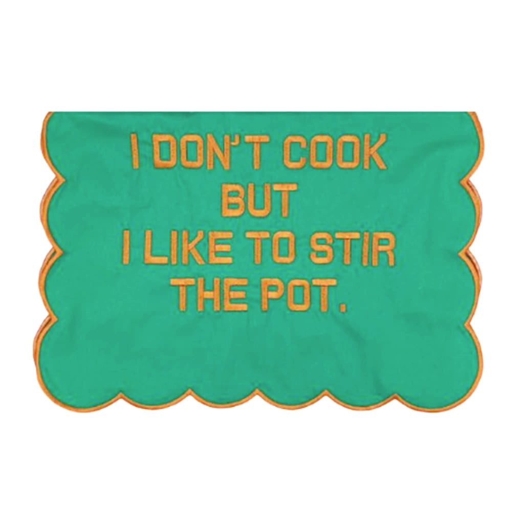 Green scallop edge tea towel with orange text 'I DON'T COOK BUT I LIKE TO STIR THE POT' and orange trim, on a white background.