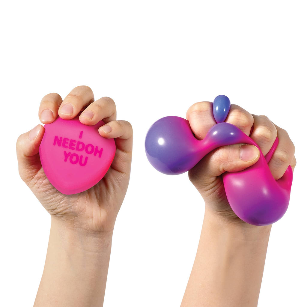 Schylling NeeDoh Color Change Squeeze Hearts squishie heart-shaped fidget toy in  hand for scale and being squished to show color change.