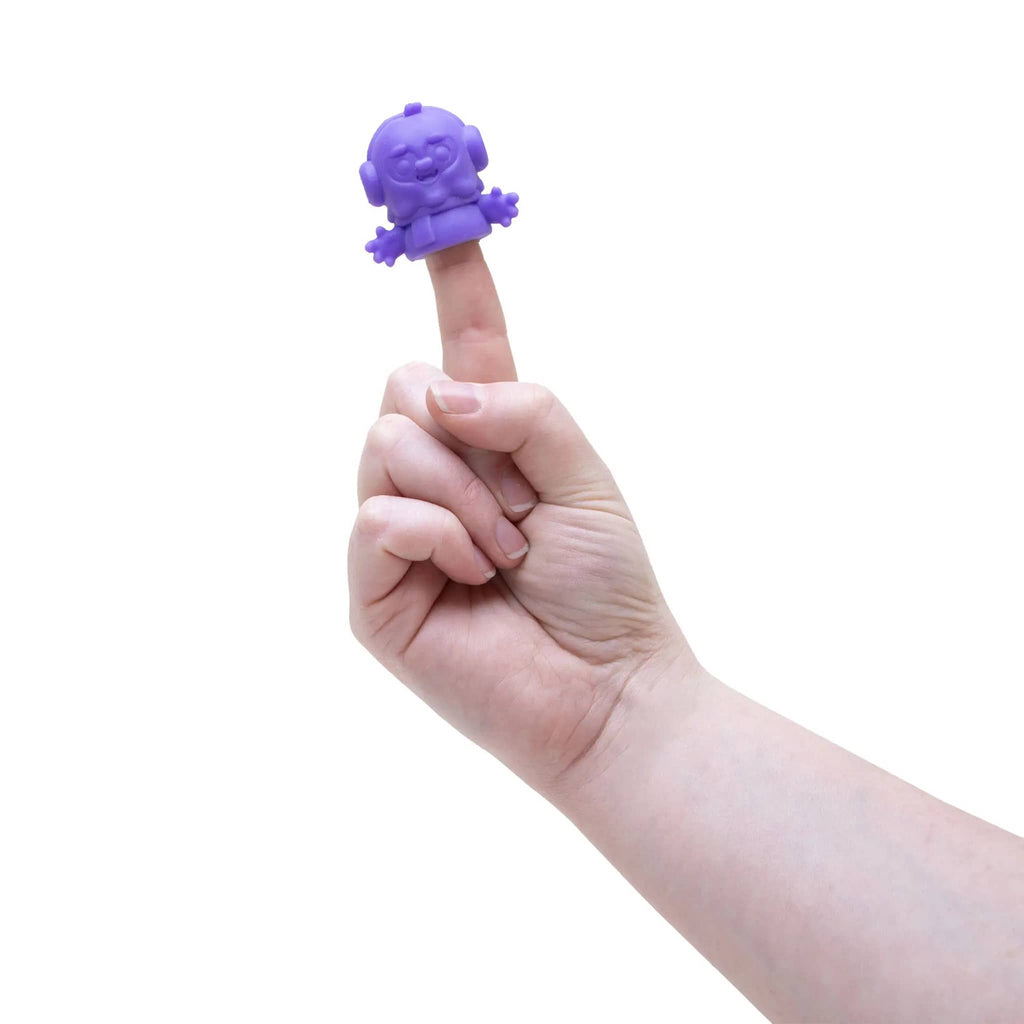 Hand holding a small purple needoh creature on a finger against a white background.