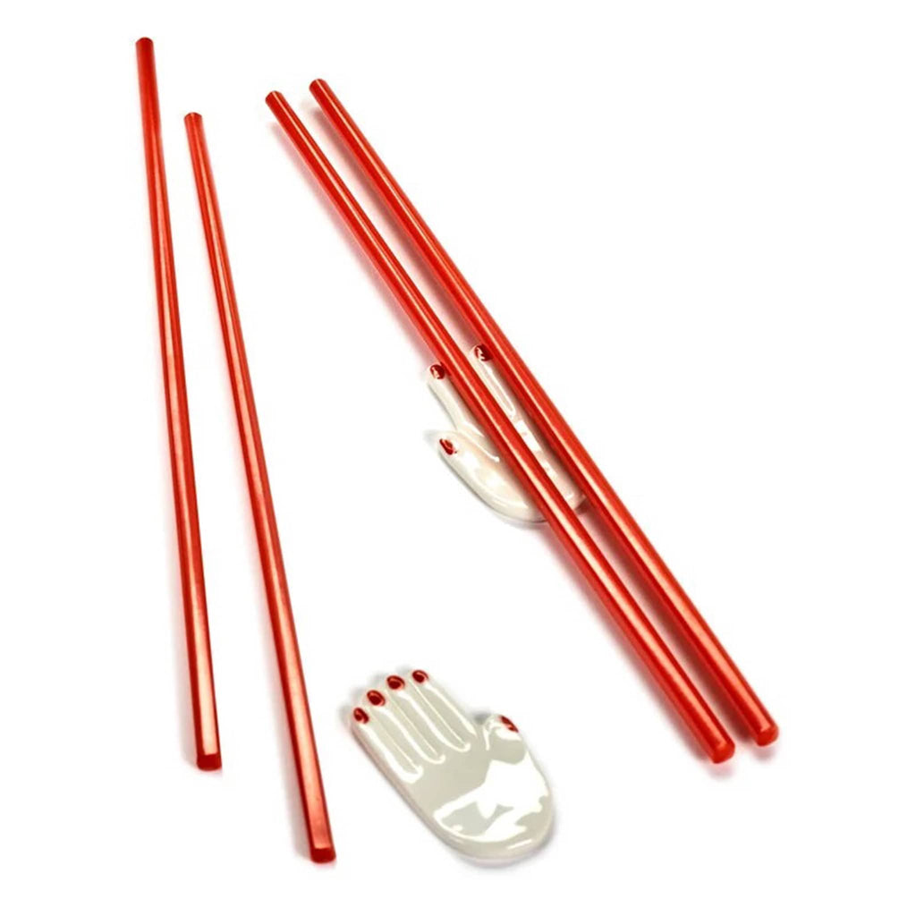 Red chopsticks with white porcelain hand-shaped holders on a white background.