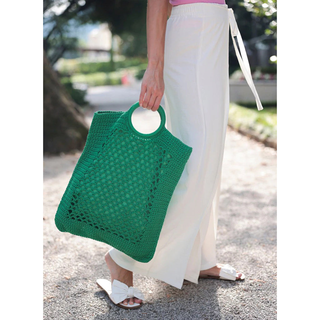 Shiraleah Jezabelle woven cotton net bag with double round handles in green, in models hand.