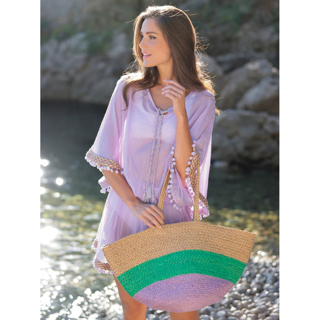 Shiraleah Liza Tote Bag with double shoulder straps and and a wide stripe of lilac and teal green on natural woven jute with model carrying it.