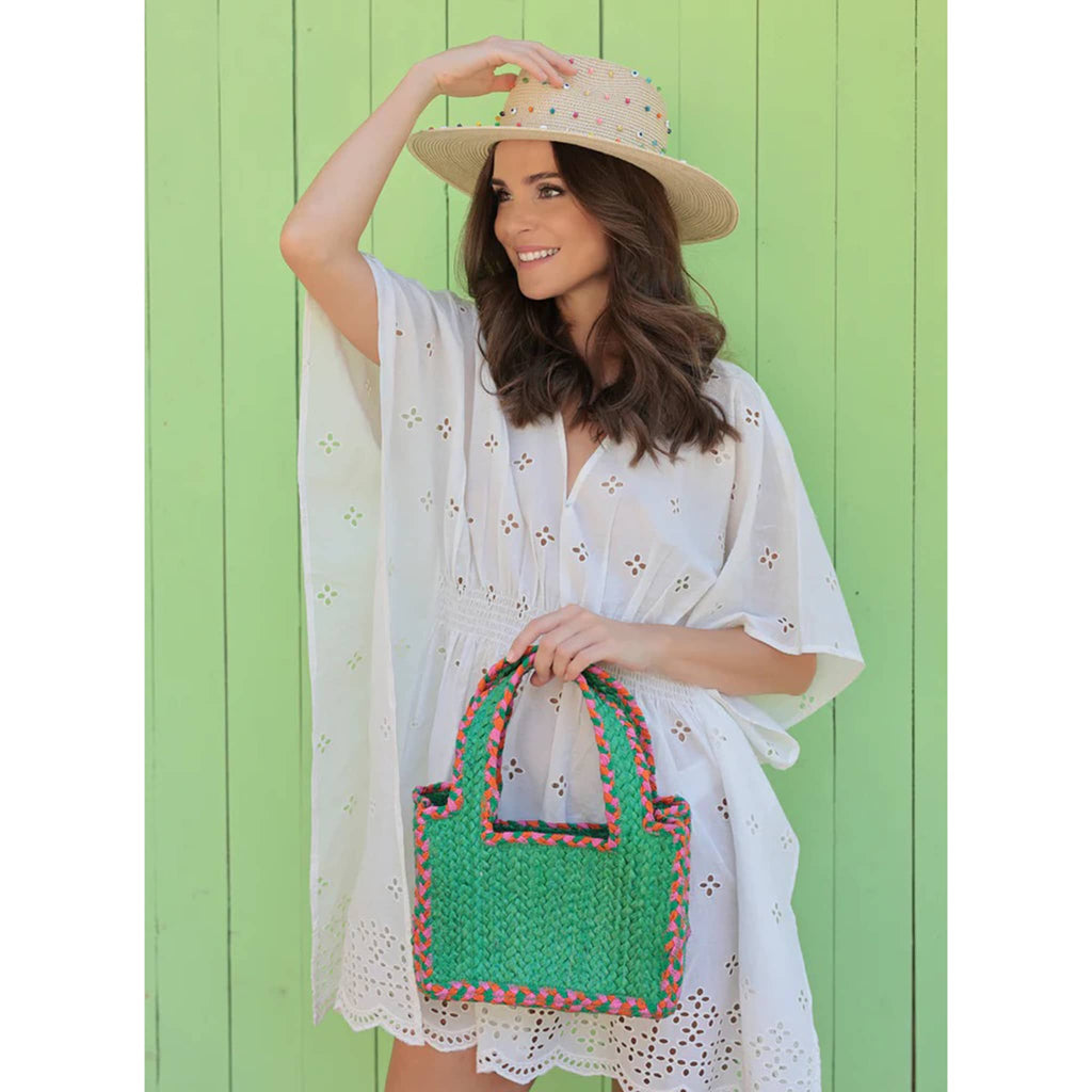 Shiraleah Liv Small Green Woven Tote with pink and orange braided seams, in model's hand.