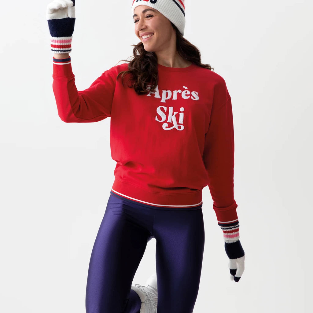 Red sweatshirt with "apres ski" in red lettering on a model, on a white background.