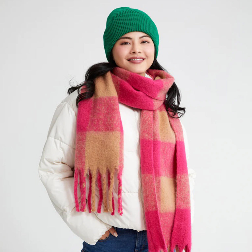 Shiraleah Hope Knit Winter Hat Beanie in solid green on model wearing a white puffy coat and pink and tan scarf.