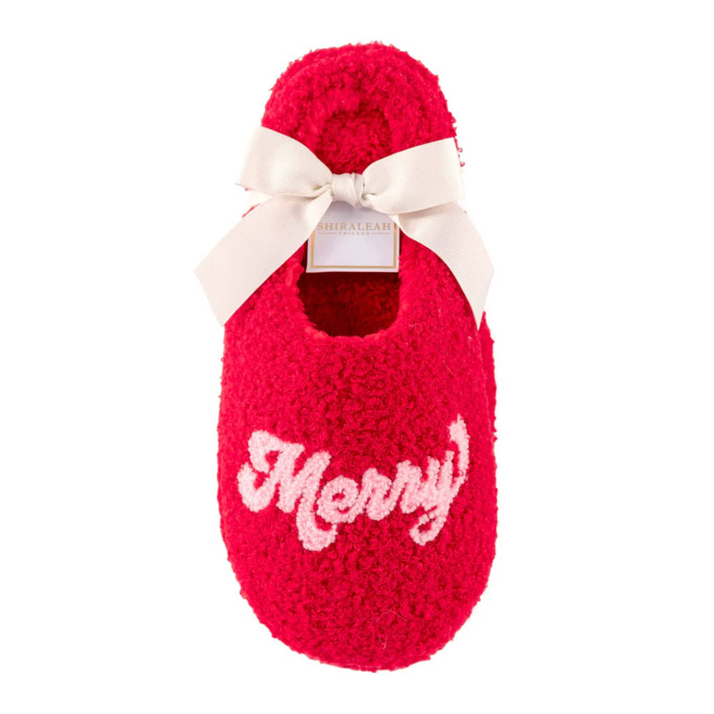 Shiraleah red sherpa slippers with "merry" across the toe in pink letters on both, in ribbon packaging.