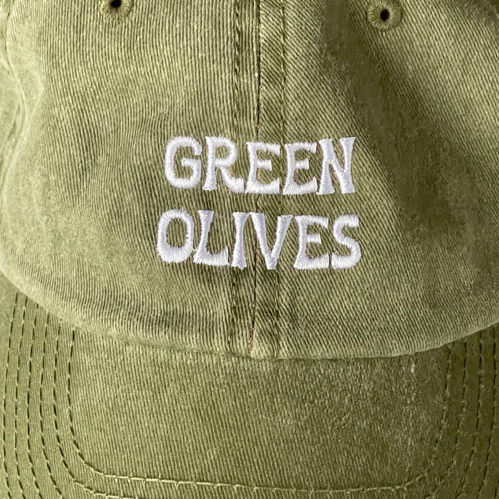 Olive green cap with 'GREEN OLIVES' embroidered in white, detail.