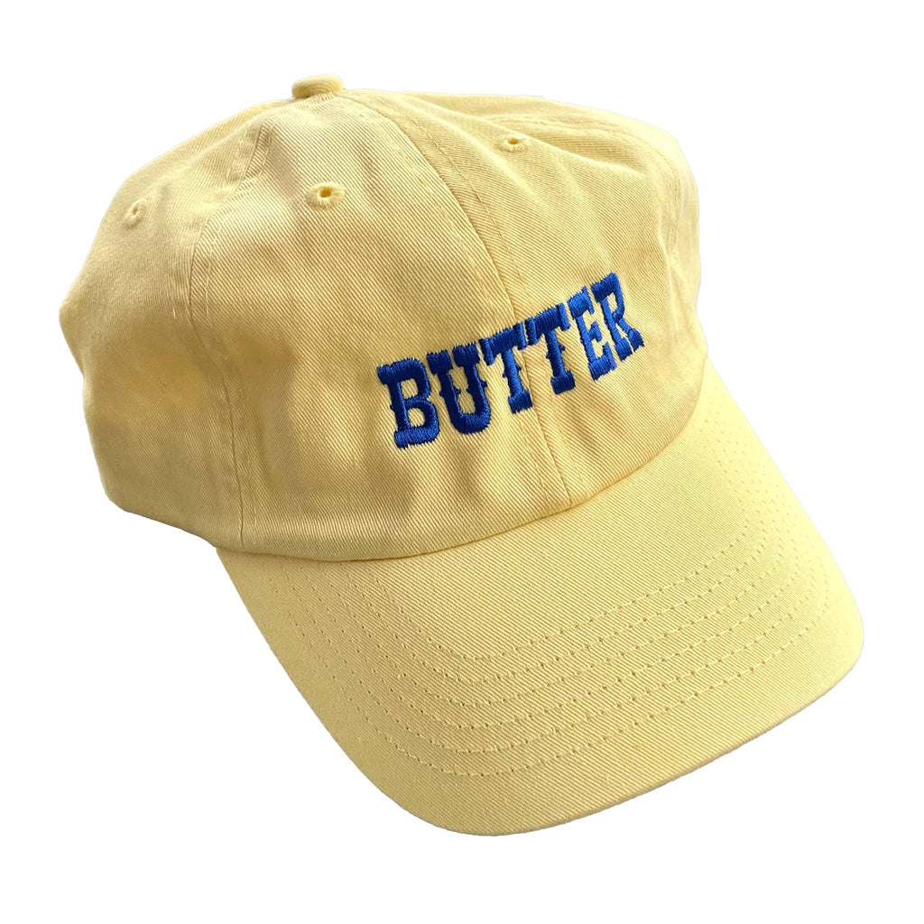 Silver Spider soft yellow unisex baseball cap with "butter" in blue embroidered letters on the front.