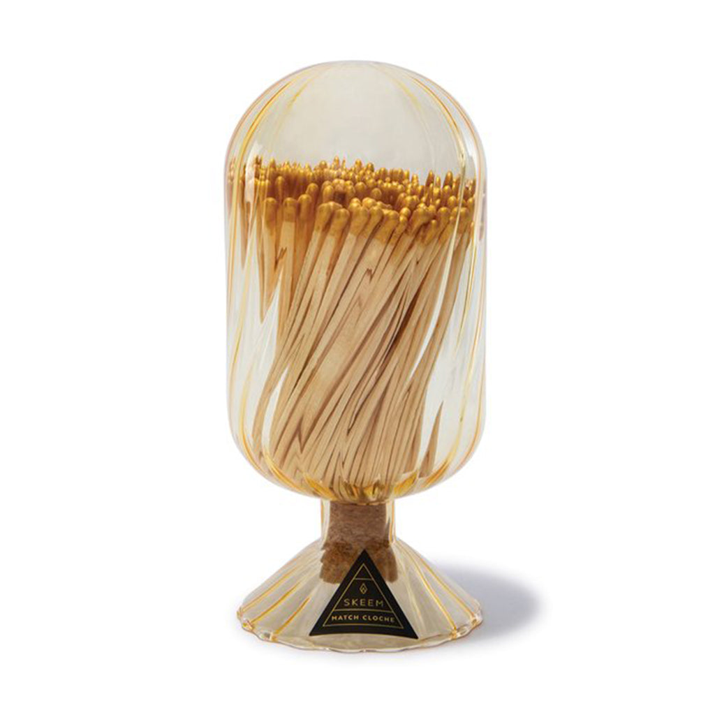 Skeem gold-tinted glass helix cloche filled with gold-tipped wooden safety matches.