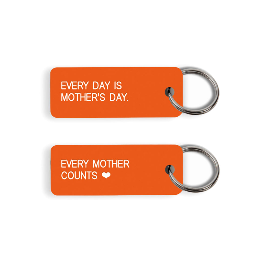 Social Goods x Every Mother Counts orange acrylic keychain with "every day is mother's day" on the front and "every mother counts" on the back.