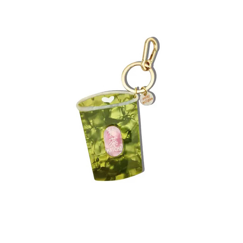 Gold tone keychain with green cup-shaped charm with a pink logo on a white background.