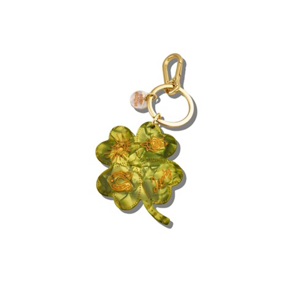 Gold keychain with a green four-leaf clover charm on a white background.