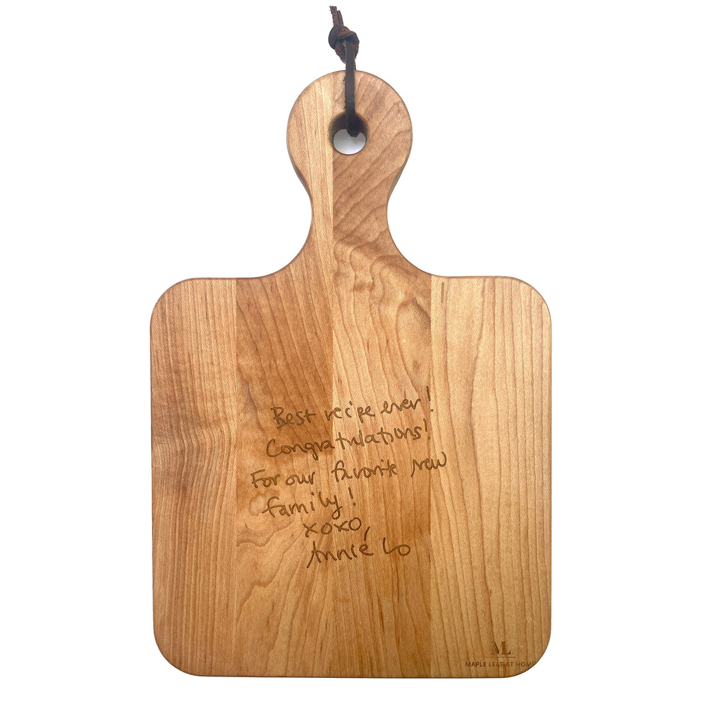 Maple Leaf at Home 12x8 maple wood artisan serving board with handwritten message engraved on the back and built-in handle.