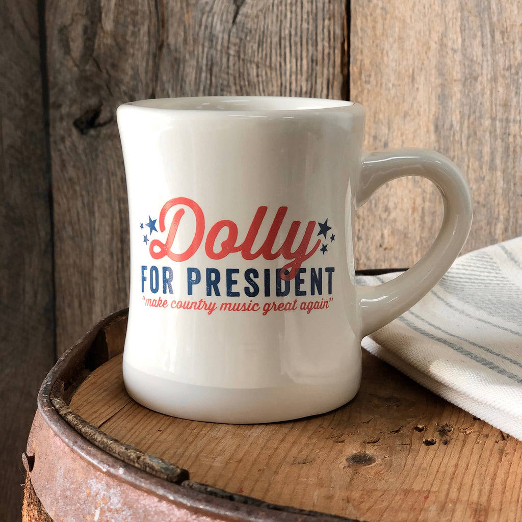 Southern Fried Design Dolly for President campaign ceramic diner mug on a wood barrel with tea towel.